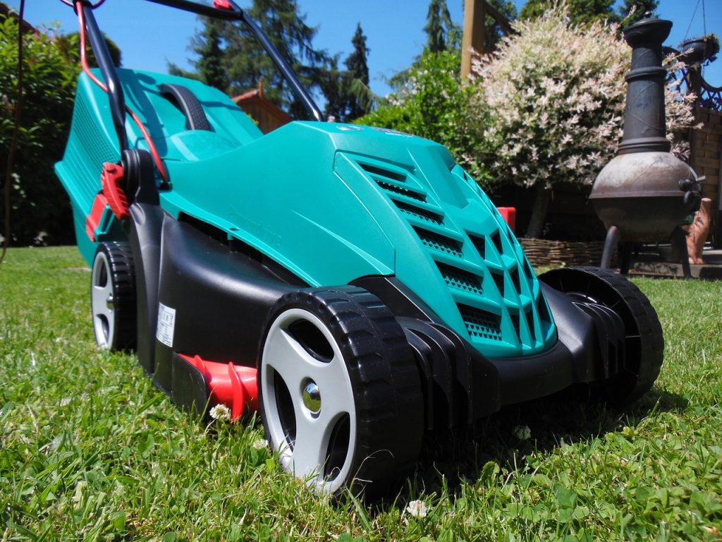 Turquoise and black electric lawn mower on grass